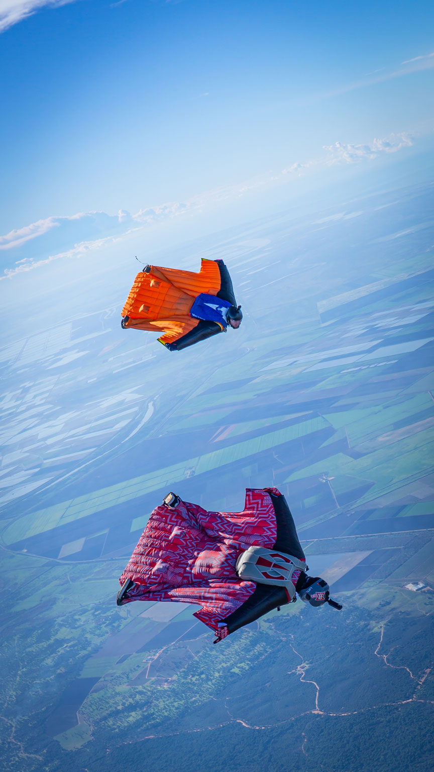 Wingsuiters in full flight soaring the sky